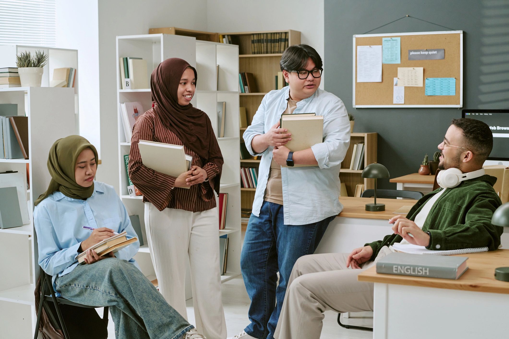Multiethnic college students discussing books in a classroom